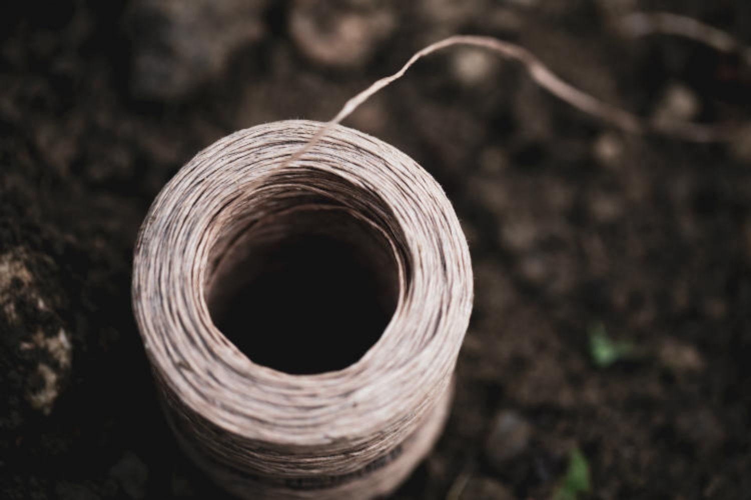 Close-up on a roll of string lying on the ground.